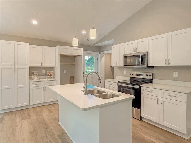 330 Code Cir, Seneca, SC 29678 - kitchen featuring stainless steel appliances, white cabinets, vaulted ceiling, light wood finished floors, and an island with sink