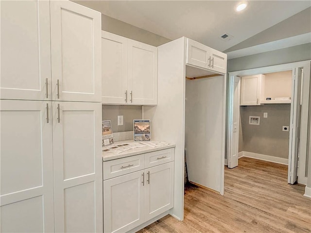 330 Code Cir, Seneca, SC 29678 - kitchen with vaulted ceiling, light countertops, white cabinets, and light wood-style flooring