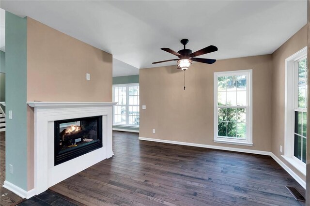 210 Briarcliff Rd, Central, SC 29630 - unfurnished living room featuring a multi sided fireplace, dark wood-type flooring, and a ceiling fan