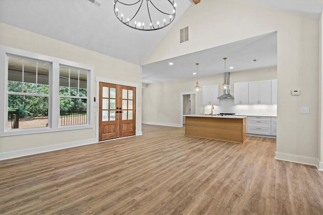 711 Concord Rd, Anderson, SC 29621 - unfurnished living room featuring high vaulted ceiling, light wood-type flooring, plenty of natural light, beam ceiling, and french doors