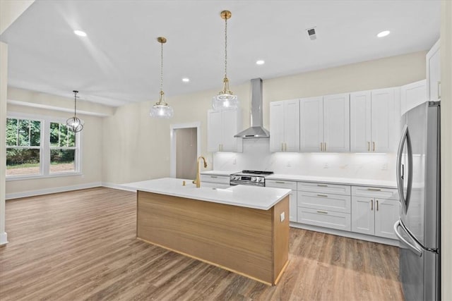 711 Concord Rd, Anderson, SC 29621 - kitchen with stainless steel appliances, wall chimney range hood, wood finished floors, light countertops, and a center island with sink