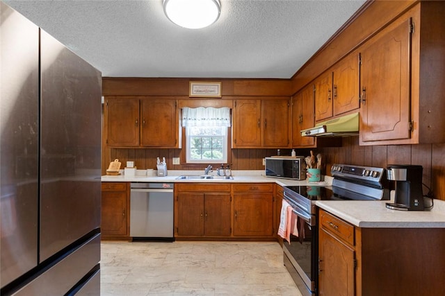 123 Radisson Rd, Seneca, SC 29678 - kitchen with stainless steel appliances, under cabinet range hood, brown cabinets, and a textured ceiling