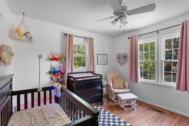 123 Radisson Rd, Seneca, SC 29678 - bedroom featuring multiple windows, wood finished floors, a textured ceiling, and ceiling fan