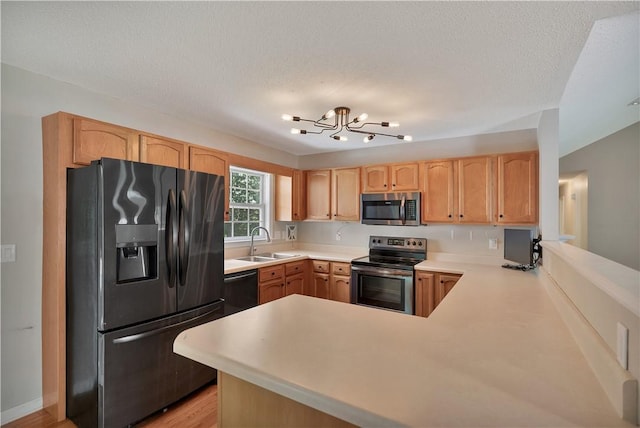 208 Playground Rd, Walhalla, SC 29691 - kitchen featuring stainless steel appliances, a peninsula, light brown cabinetry, light countertops, and a chandelier