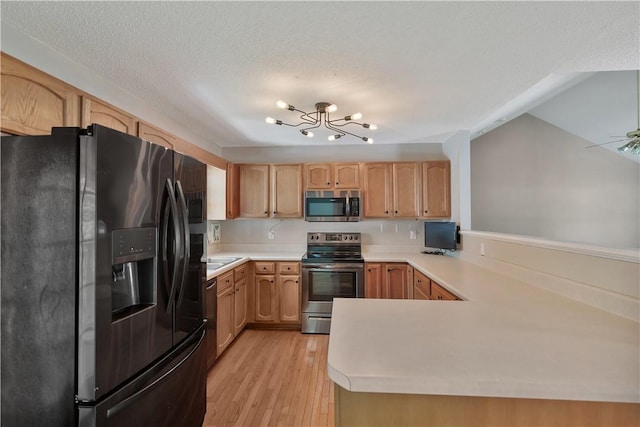 208 Playground Rd, Walhalla, SC 29691 - kitchen with appliances with stainless steel finishes, light countertops, a peninsula, light wood-type flooring, and a textured ceiling