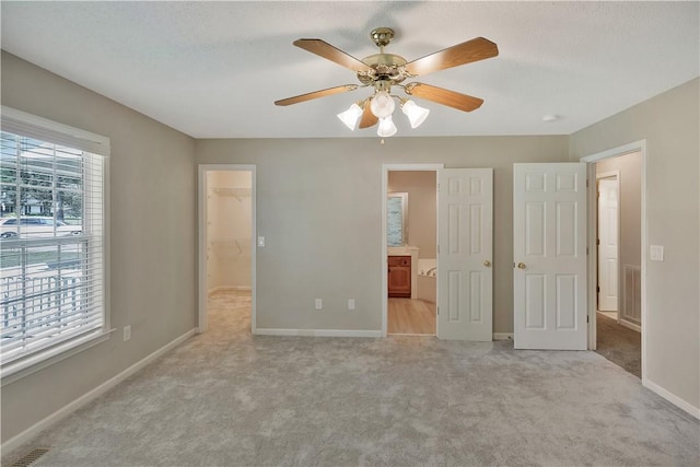 208 Playground Rd, Walhalla, SC 29691 - unfurnished bedroom featuring a walk in closet, light colored carpet, a ceiling fan, and connected bathroom
