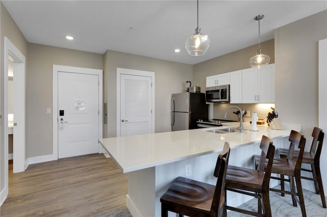 13500 Clemson Blvd Unit 1201Ab, Seneca, SC 29678 - kitchen featuring stainless steel microwave, freestanding refrigerator, a peninsula, light wood-style flooring, and light countertops