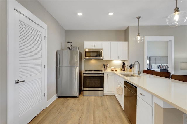 13500 Clemson Blvd Unit 1201Ab, Seneca, SC 29678 - kitchen featuring appliances with stainless steel finishes, light wood finished floors, decorative backsplash, white cabinetry, and pendant lighting