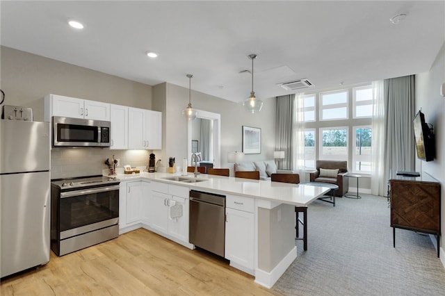 13500 Clemson Blvd Unit 1201Ab, Seneca, SC 29678 - kitchen with appliances with stainless steel finishes, a peninsula, open floor plan, white cabinetry, and a breakfast bar area