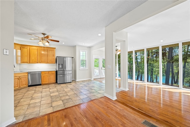 168 Wilderness Pt, Hartwell, GA 30643 - kitchen featuring stainless steel appliances, ceiling fan, light wood-style floors, light countertops, and a textured ceiling