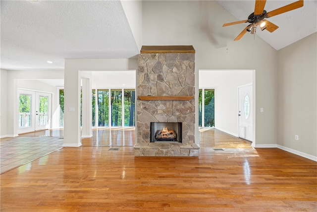 168 Wilderness Pt, Hartwell, GA 30643 - unfurnished living room featuring wood finished floors, healthy amount of natural light, a fireplace, ceiling fan, and high vaulted ceiling