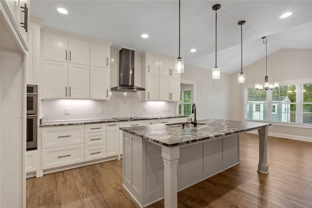 340 Fiddlers Way, Seneca, SC 29678 - kitchen featuring wall chimney range hood, wood finished floors, dark stone countertops, lofted ceiling, and white cabinets