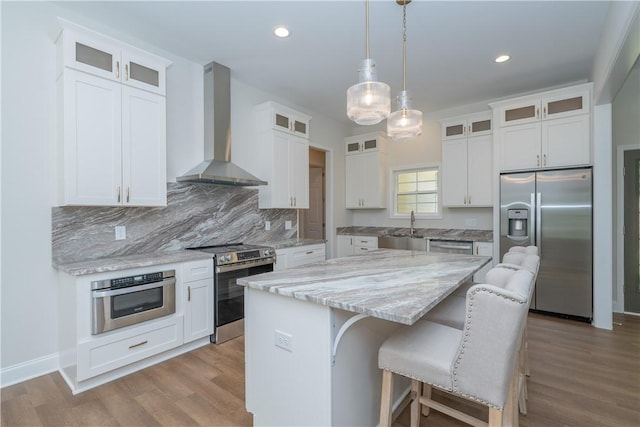 218 W Halfway Branch Rd, Walhalla, SC 29691 - kitchen featuring wall chimney exhaust hood, stainless steel appliances, a kitchen island, light stone counters, and a kitchen bar