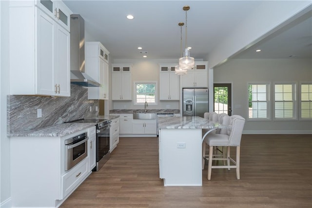 218 W Halfway Branch Rd, Walhalla, SC 29691 - kitchen featuring appliances with stainless steel finishes, wall chimney exhaust hood, a kitchen breakfast bar, a kitchen island, and dark wood-style floors