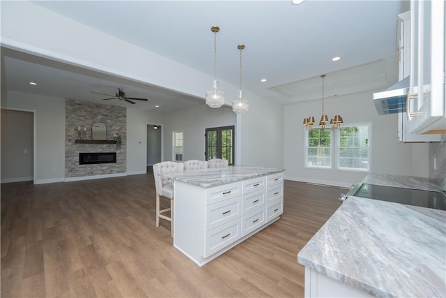 218 W Halfway Branch Rd, Walhalla, SC 29691 - kitchen with ceiling fan, light wood-style floors, white cabinets, a breakfast bar area, and hanging light fixtures