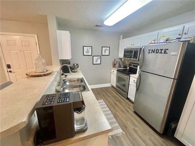726 Lookover Dr Unit 726, Anderson, SC 29621 - kitchen featuring stainless steel appliances, a textured ceiling, light countertops, light wood-style floors, and white cabinetry