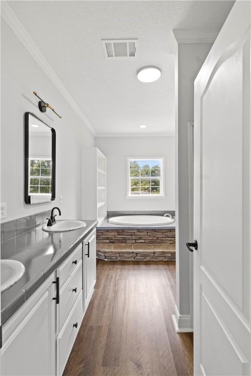 973 Pine Plain Rd, Gaston, SC 29053 - full bathroom with crown molding, double vanity, healthy amount of natural light, wood finished floors, and a bath
