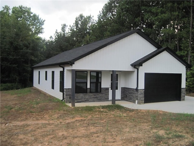 203 Ridgecrest Way, Williamston, SC 29697 - modern inspired farmhouse featuring stone siding, an attached garage, a porch, and concrete driveway