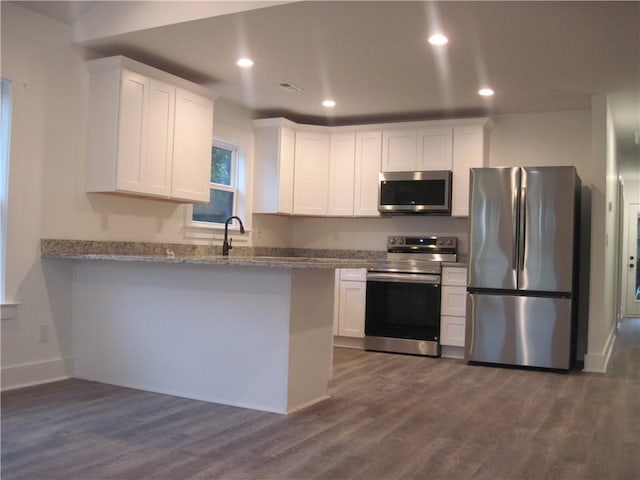 203 Ridgecrest Way, Williamston, SC 29697 - kitchen featuring appliances with stainless steel finishes, white cabinets, dark wood-style flooring, a peninsula, and recessed lighting
