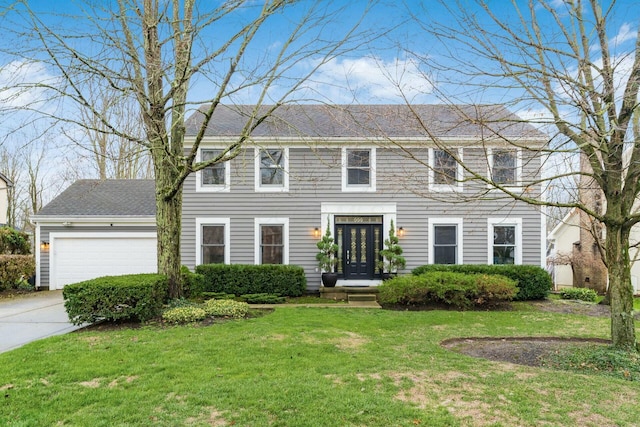 colonial home featuring a garage and a front lawn