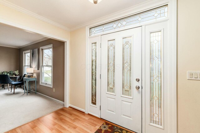 foyer featuring crown molding and light hardwood / wood-style flooring