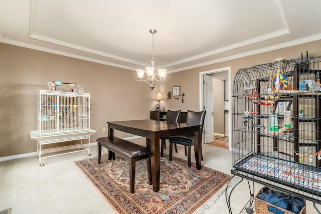 carpeted dining area with a tray ceiling, an inviting chandelier, and crown molding