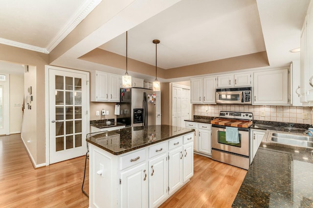 kitchen with white cabinets, appliances with stainless steel finishes, pendant lighting, and sink