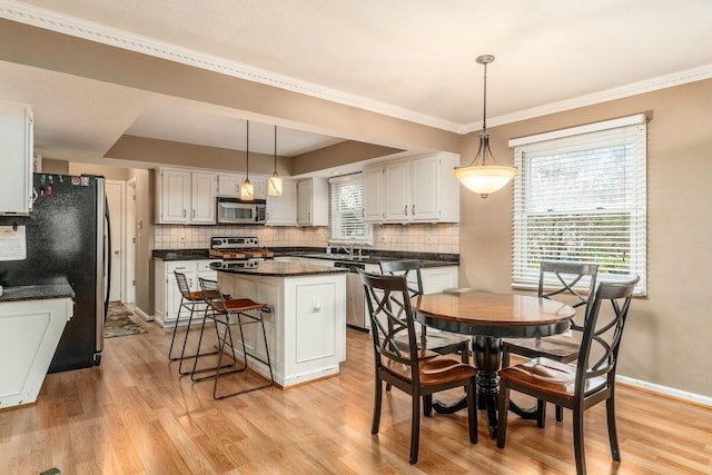 dining space featuring light hardwood / wood-style flooring and ornamental molding