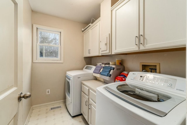 laundry area featuring washer and clothes dryer and cabinets