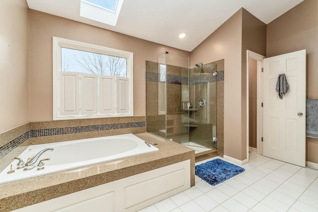 bathroom featuring vaulted ceiling with skylight, independent shower and bath, and tile patterned flooring