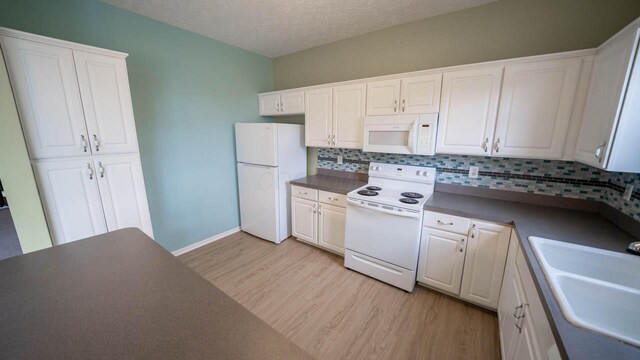 5901 Hickory Brook Way, Columbus, OH 43213 - kitchen featuring white appliances, light wood-style floors, decorative backsplash, white cabinets, and dark countertops