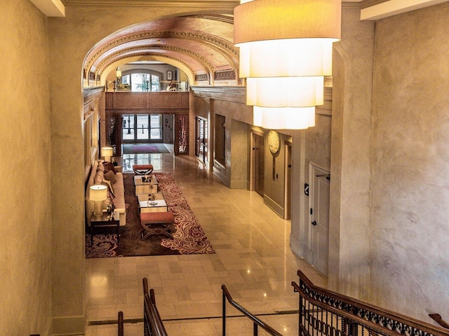 hallway with a towering ceiling and ornamental molding