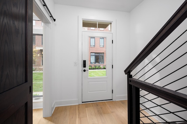 entryway featuring a healthy amount of sunlight, light hardwood / wood-style floors, and a barn door