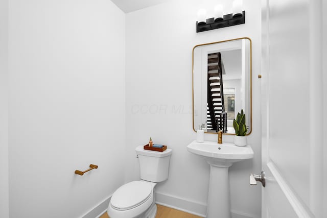 bathroom with toilet and hardwood / wood-style flooring