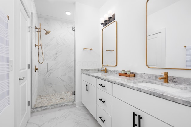 bathroom with a shower with shower door and vanity