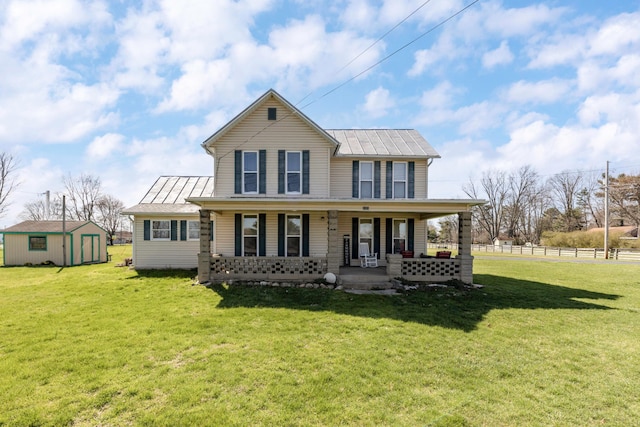 view of front facade featuring a front yard, a porch, and a shed