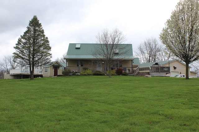 rear view of property with a storage unit and a yard