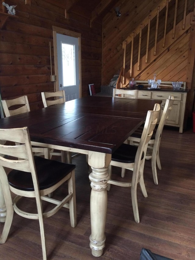 dining space with wooden walls and dark hardwood / wood-style floors