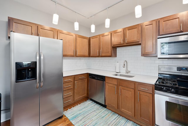119 Redbud Aly, Columbus, OH 43206 - kitchen with appliances with stainless steel finishes, light countertops, backsplash, light wood-type flooring, and brown cabinetry