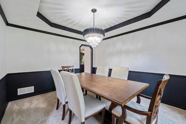 12627 Oakmere Dr, Pickerington, OH 43147 - dining area featuring light carpet, a chandelier, arched walkways, ornamental molding, and a raised ceiling