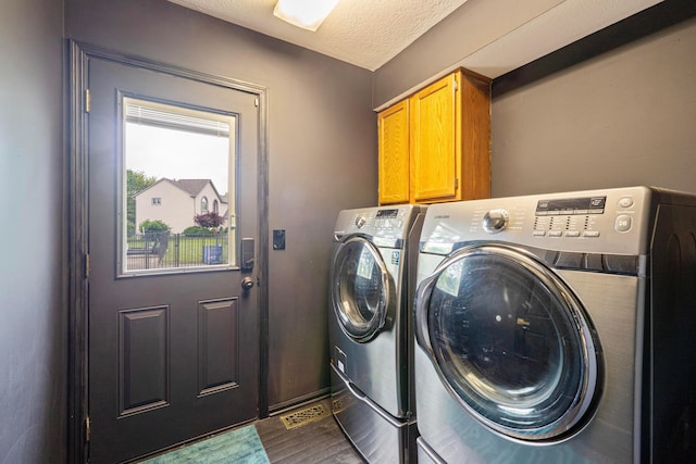 12627 Oakmere Dr, Pickerington, OH 43147 - laundry room featuring washer and dryer, cabinet space, dark wood finished floors, and a textured ceiling
