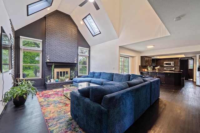 12627 Oakmere Dr, Pickerington, OH 43147 - living area featuring dark wood-style flooring, a ceiling fan, a skylight, a fireplace, and high vaulted ceiling