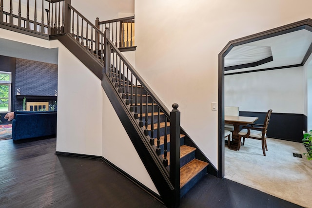 12627 Oakmere Dr, Pickerington, OH 43147 - stairway with wood finished floors, baseboards, a towering ceiling, and a fireplace