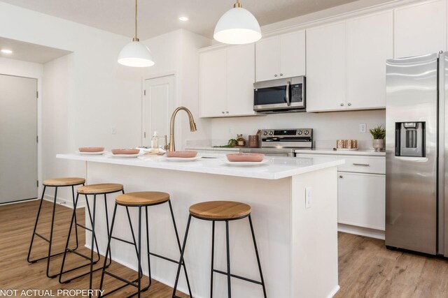 344 Postle Blvd, Columbus, OH 43228 - kitchen featuring light wood finished floors, a kitchen breakfast bar, white cabinetry, and stainless steel appliances