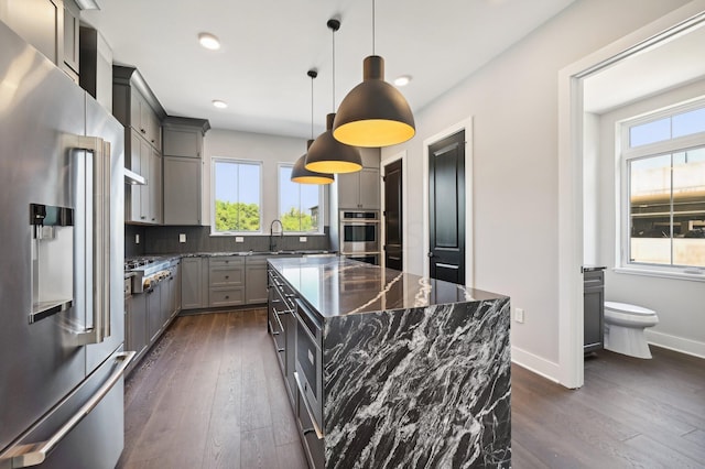 kitchen featuring pendant lighting, a center island, gray cabinets, and high end fridge