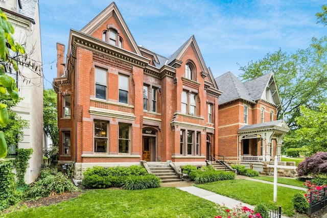 victorian house featuring a porch and a front lawn