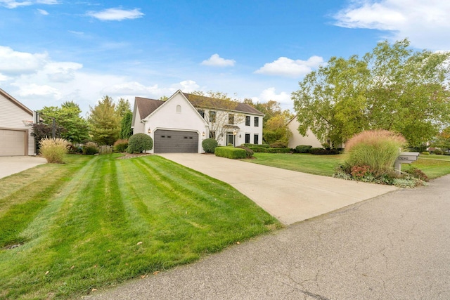 view of front facade featuring an attached garage, driveway, a front yard, and stucco siding