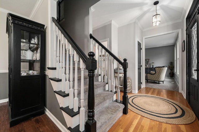 interior space featuring crown molding, baseboards, stairway, and dark wood-style flooring