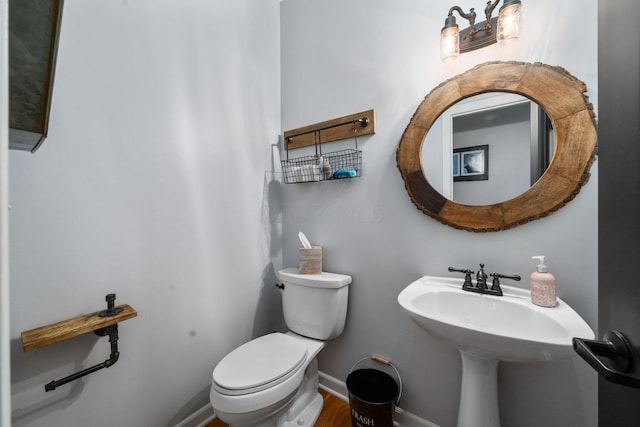 bathroom with baseboards and toilet