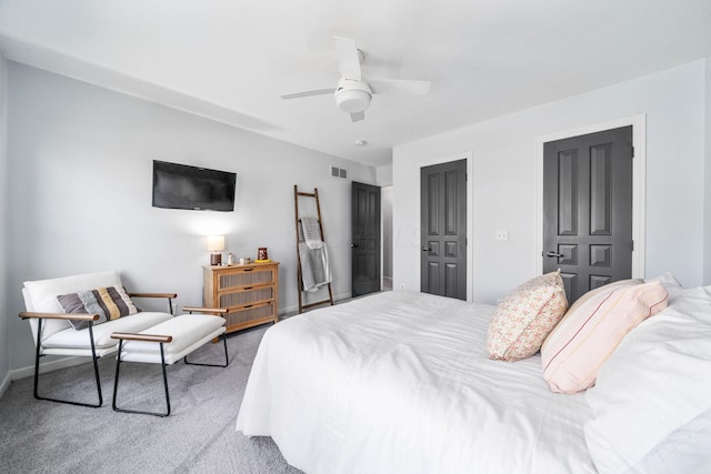 carpeted bedroom featuring baseboards, a ceiling fan, and visible vents